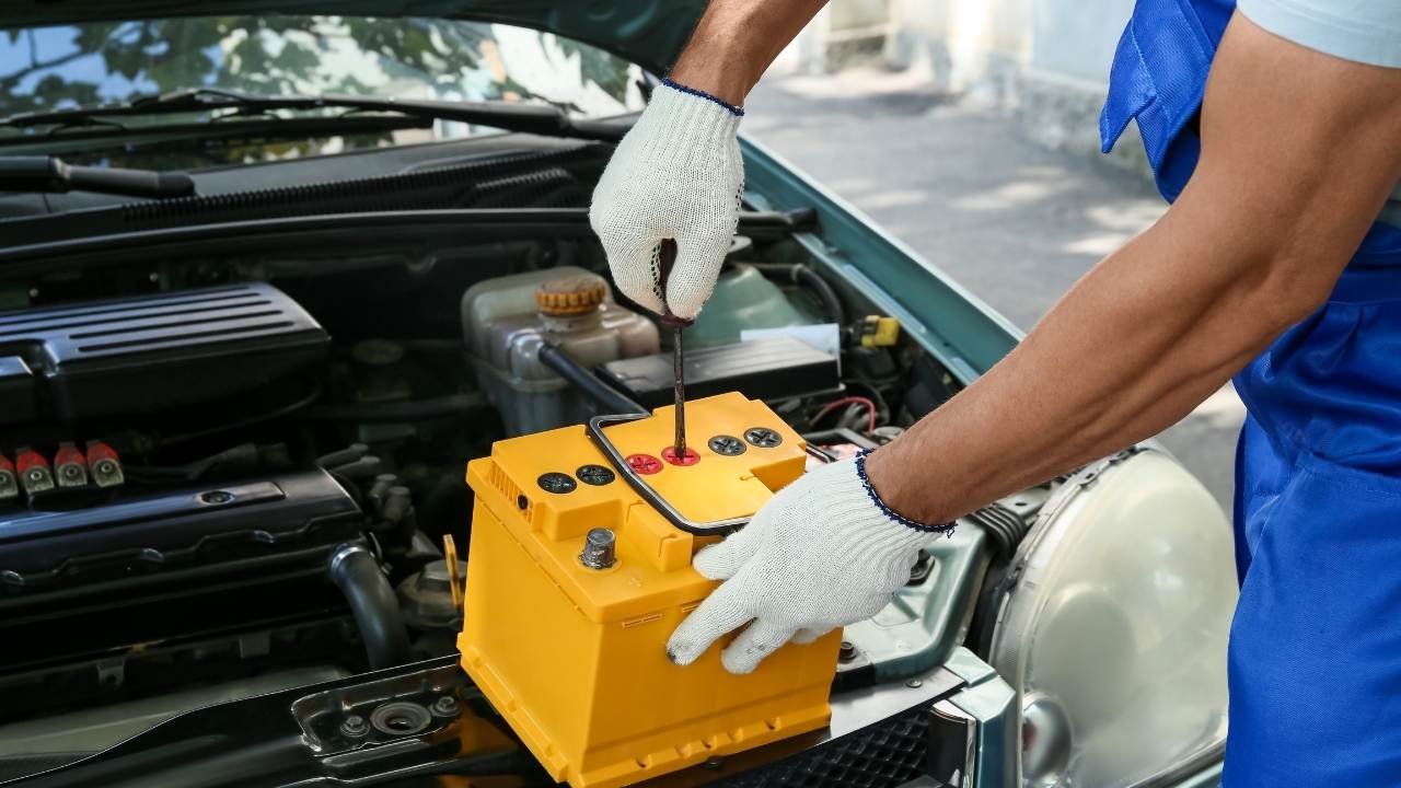 técnico instalando bateria de carro